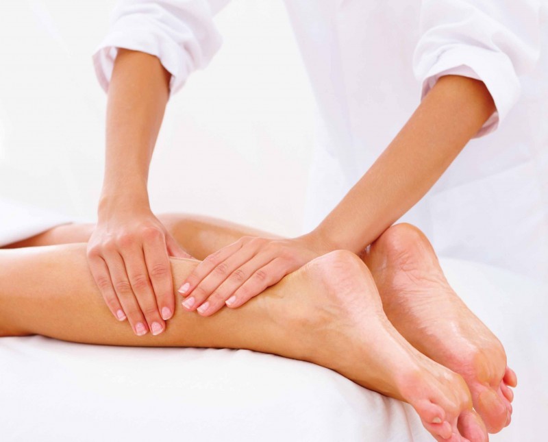 Closeup of legs receiving massage on white